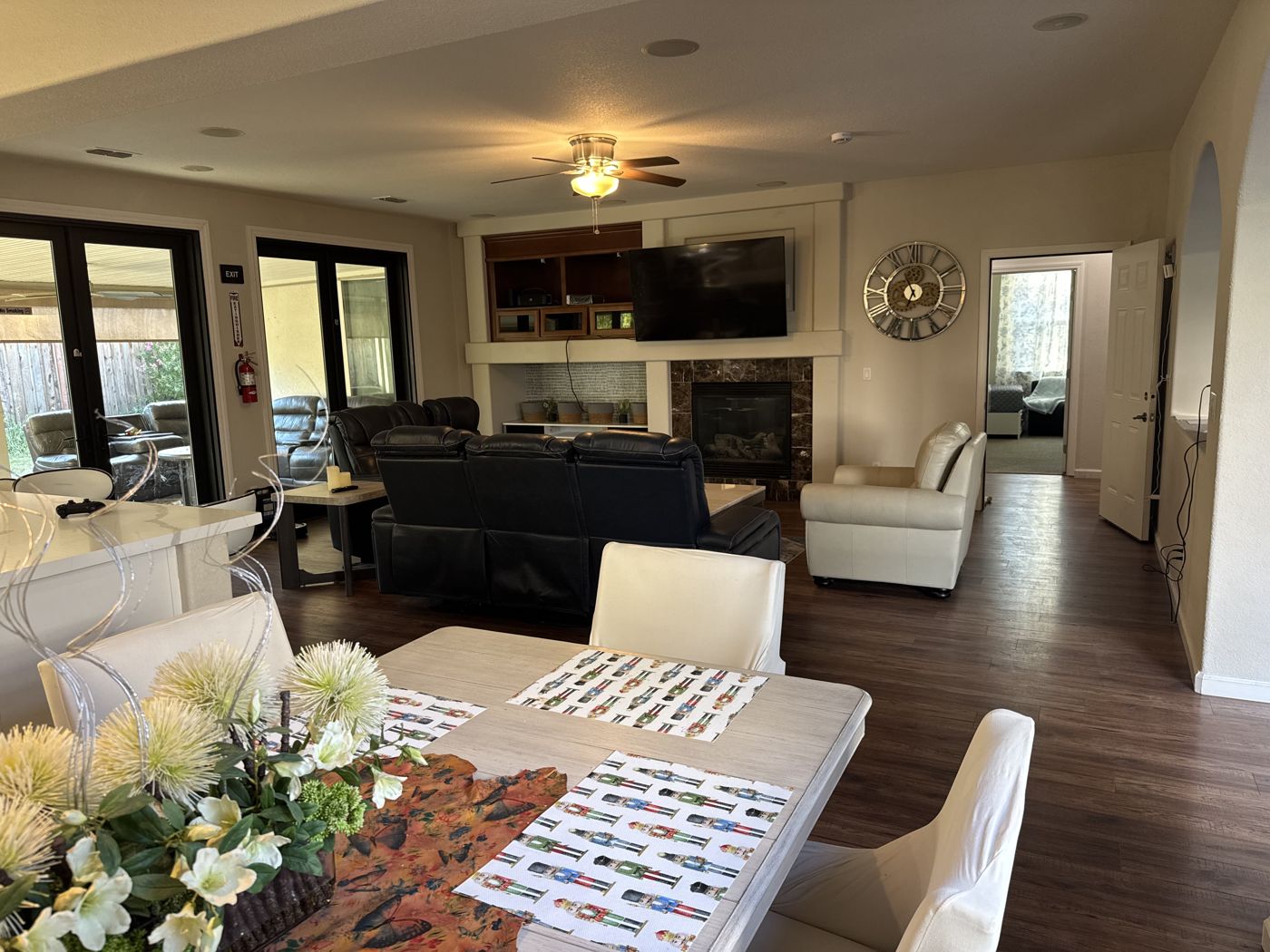 Great room with dining table, fireplace, and seating opening to the rest of the home.